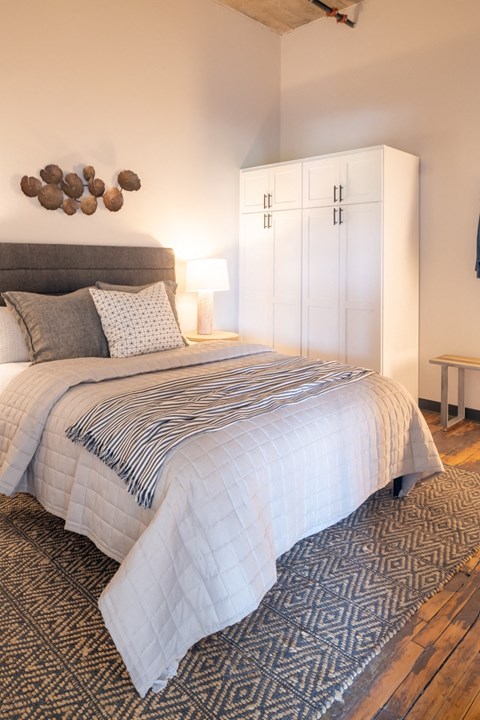 a bedroom with a large bed and a white wardrobe at The Draper, Missouri